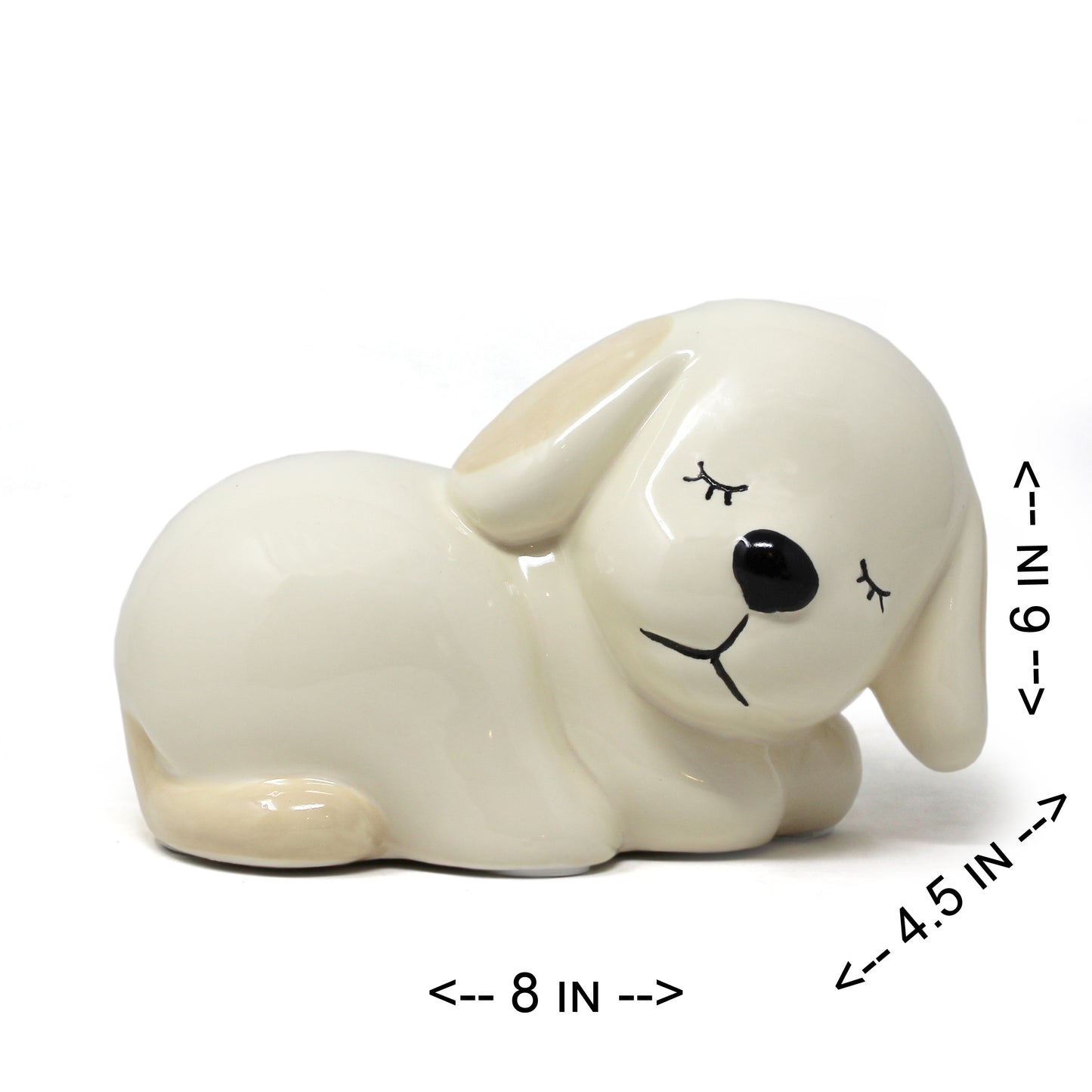 Side view of handpainted ceramic sleeping puppy piggy bank with measurements 8 inches long, 4.5 inches wide, and 6 inches tall
