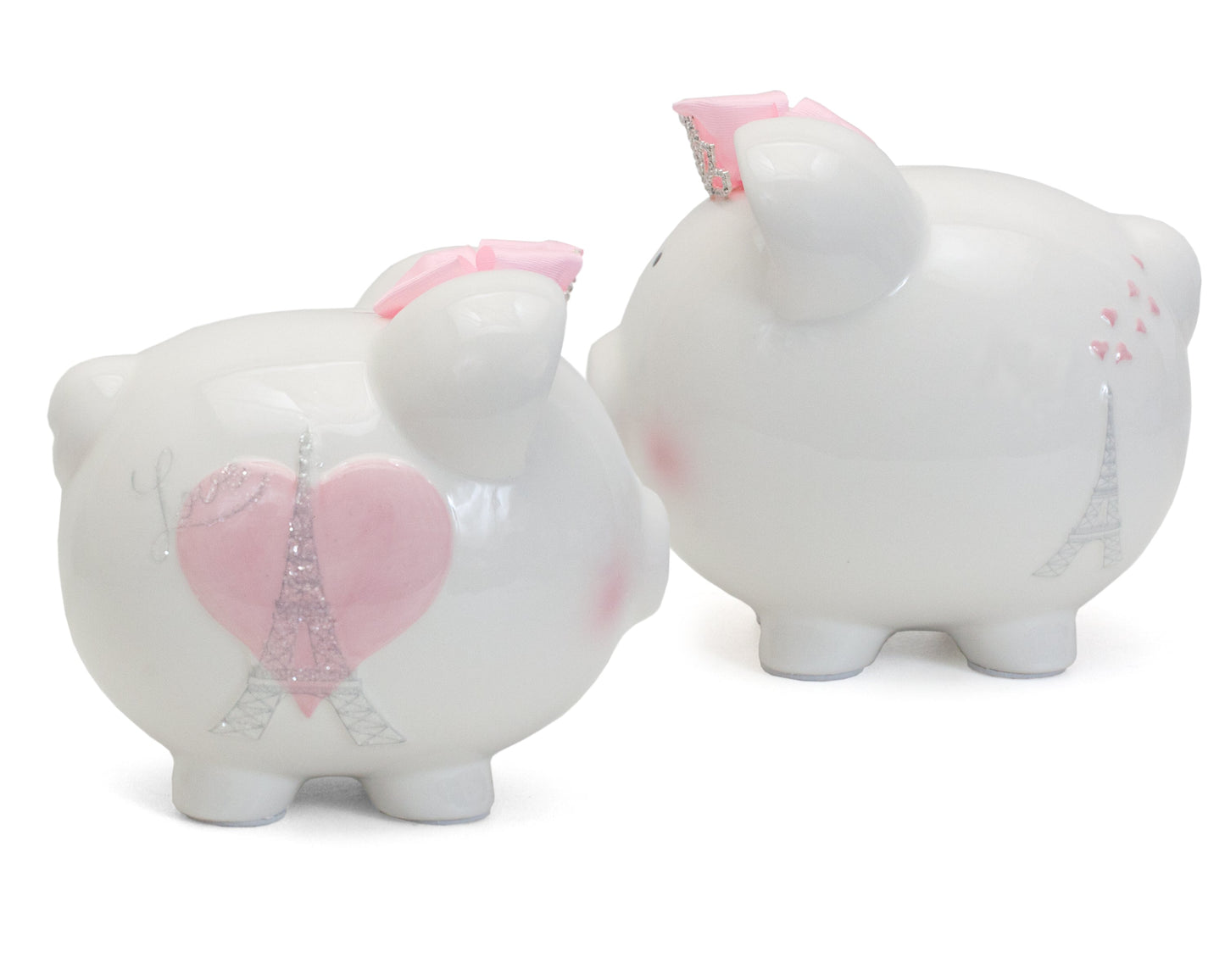 Two white ceramic piggy banks side by side showing front with pink heart and Eiffel Tower and back with Eiffel Tower and hearts designs