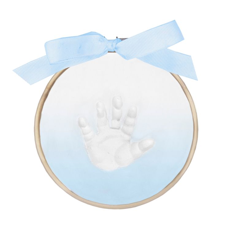 Close-up of finished ombré painted handprint in clay with blue ribbon on wooden ring