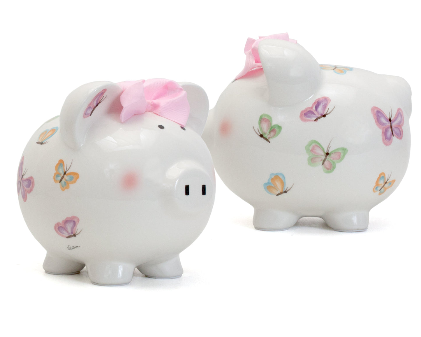 Close-up side view of white ceramic piggy bank with handpainted butterflies and pink bow