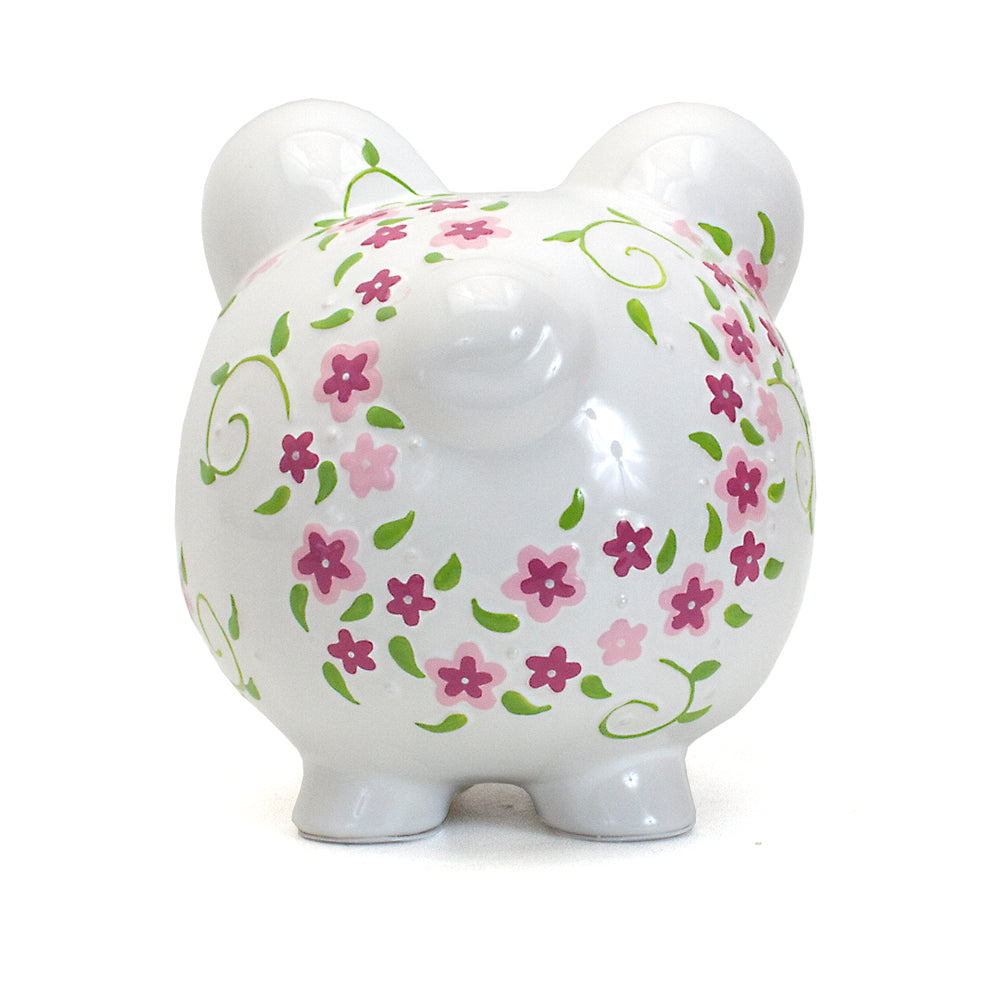 Back left side angle of white piggy bank adorned with pink and purple flowers