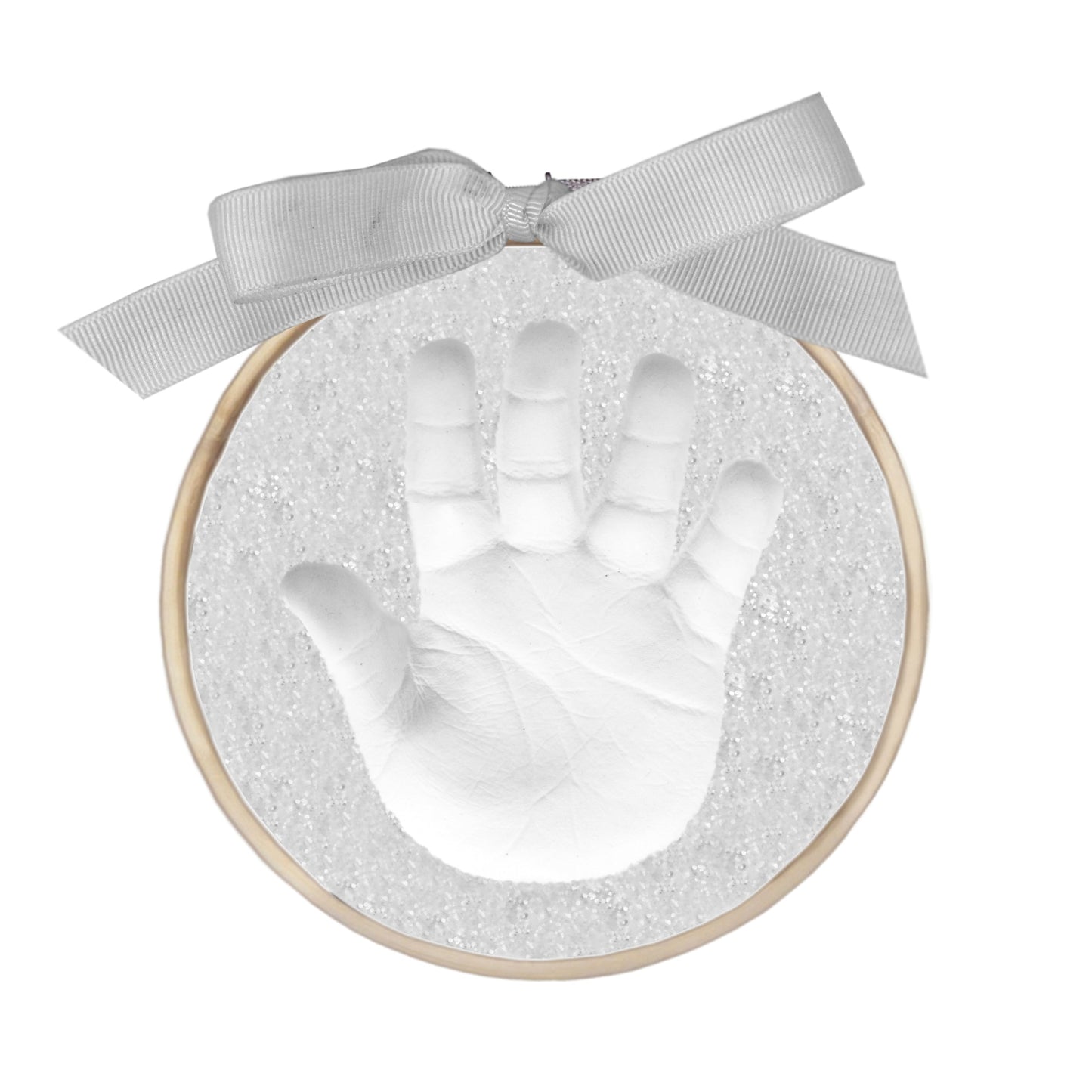 Close-up of white baby handprint cast in glittery gray backing with wooden ring and gray bow