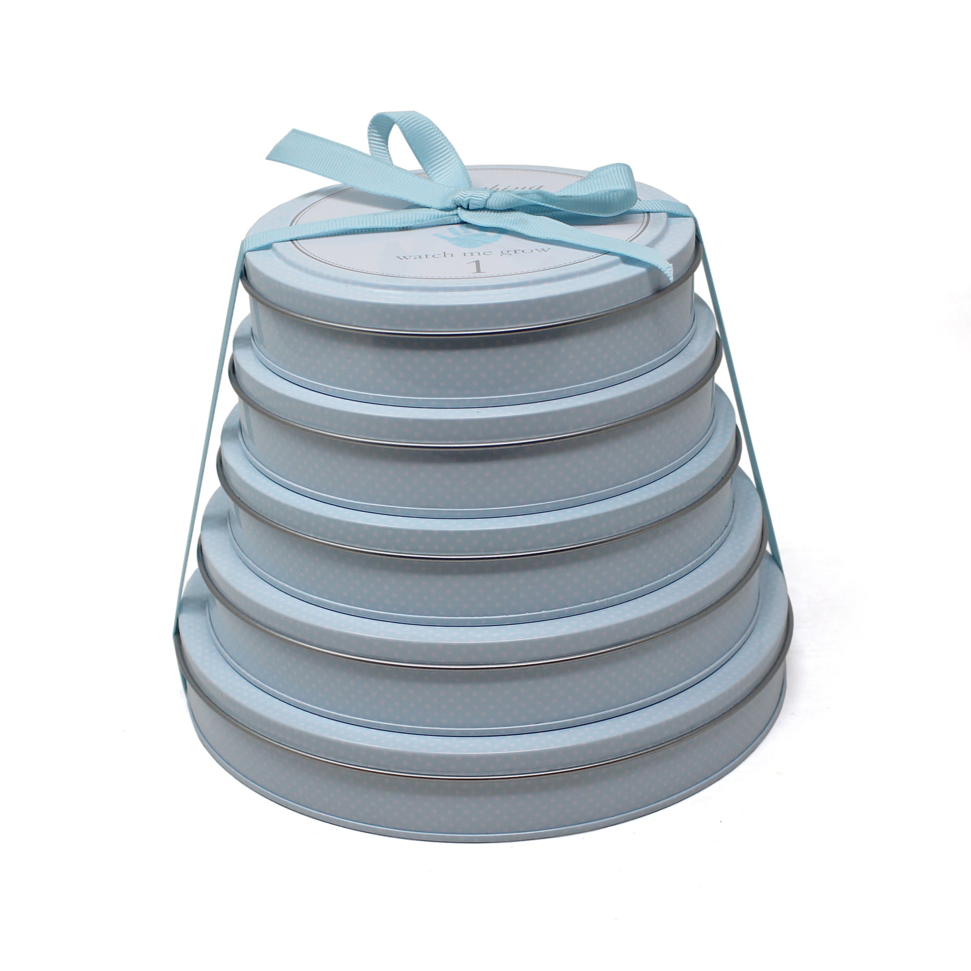 Stacked blue circular tins with handprint keepsake kits tied with a blue ribbon