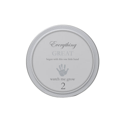 Gray tin labeled watch me grow 2 with a handprint design