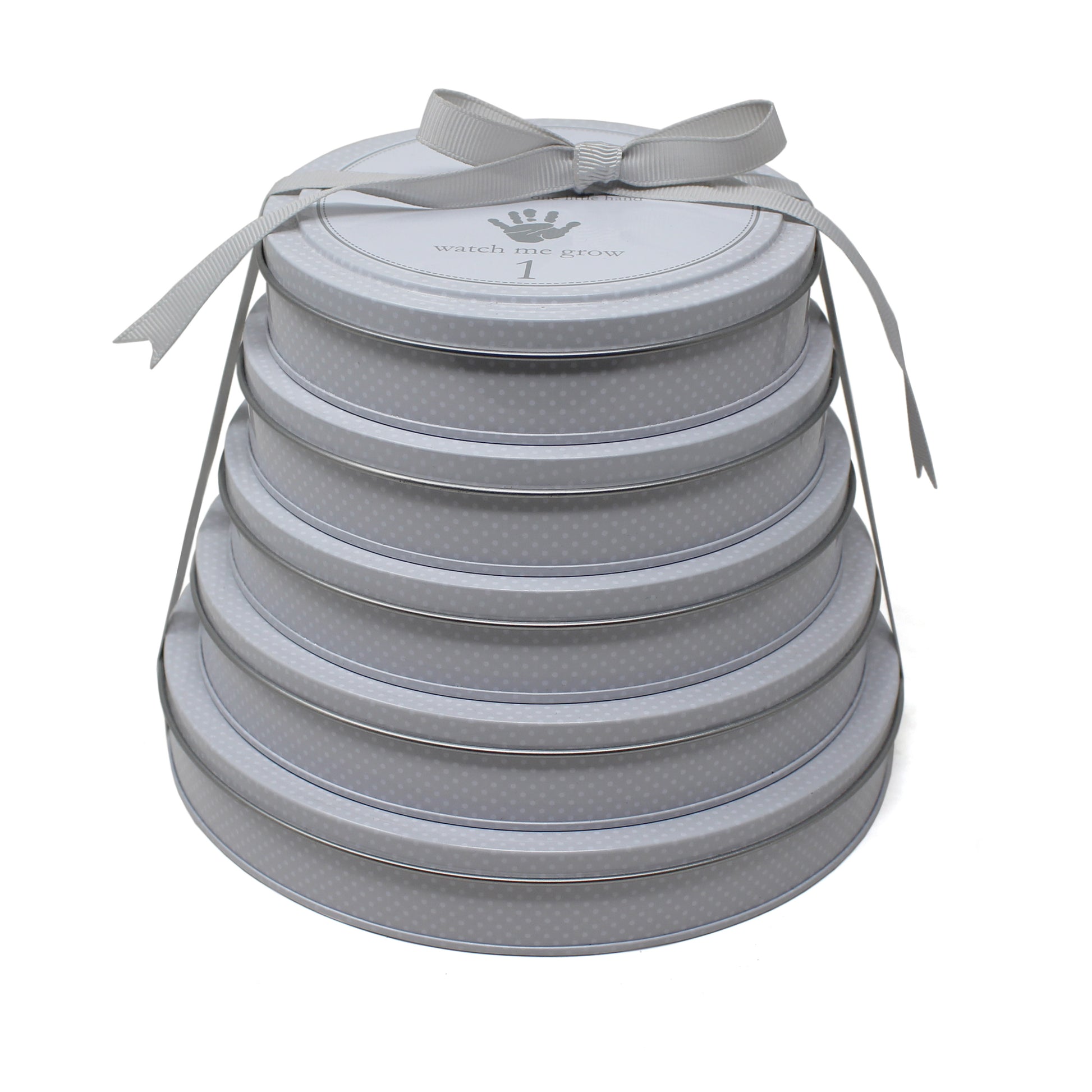 Stacked gray Tower of Time handprint tins tied with a gray ribbon