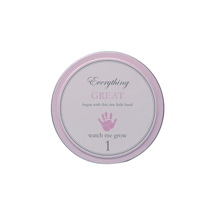 Top view of tin labeled with text 'Everything GREAT began with this one little hand 1 watch me grow'