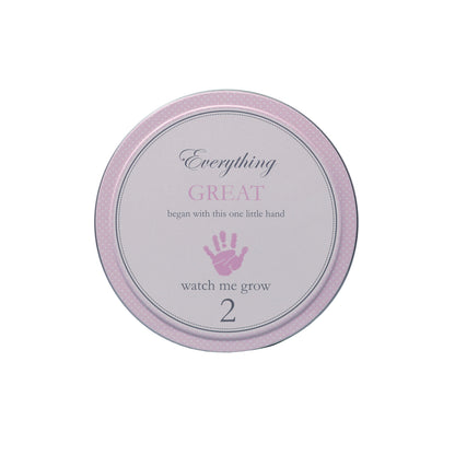 Top view of tin labeled with text 'Everything GREAT began with this one little hand 2 watch me grow'