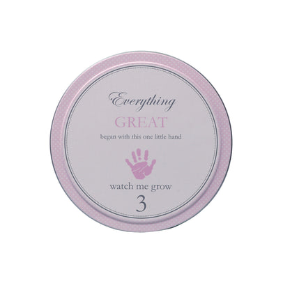 Top view of tin labeled with text 'Everything GREAT began with this one little hand 3 watch me grow'