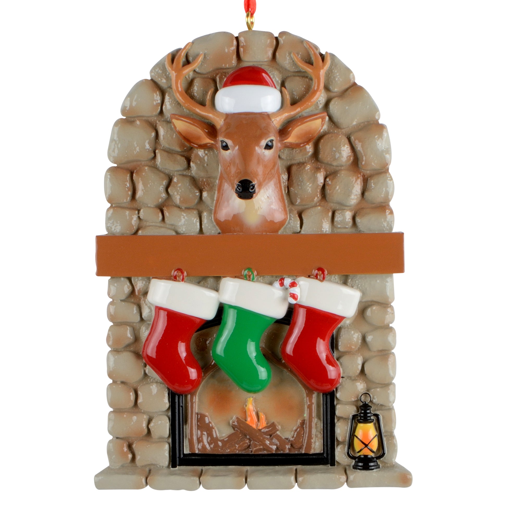 Handpainted Christmas ornament featuring a stone fireplace with a deer head wearing a Santa hat, three hanging stockings, and a lantern.