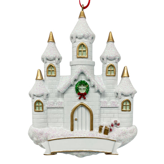 White castle holiday ornament with snow-covered roof, gold-trimmed windows, green wreath with red bow, candy canes, and blank banner