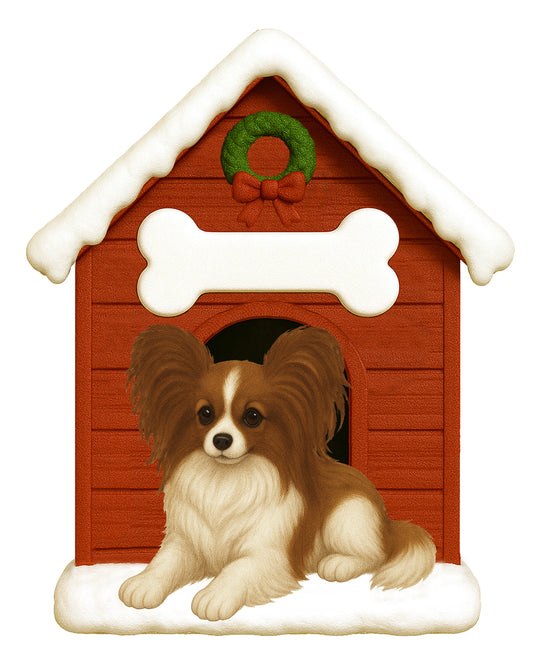 Handpainted holiday ornament of a Papillon dog resting in front of a red snow-covered doghouse decorated with a white bone and Christmas wreath