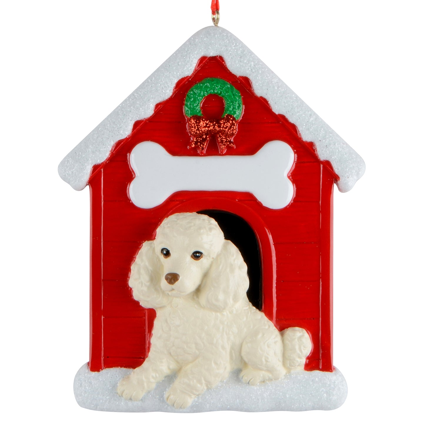 Holiday ornament featuring a white poodle sitting in front of a red doghouse decorated with a green wreath and snowy roof