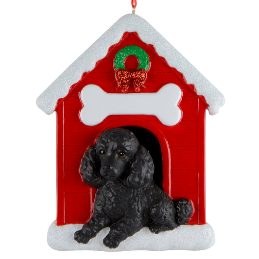 Handpainted Christmas ornament of a black poodle sitting in front of a red doghouse with snow and a wreath