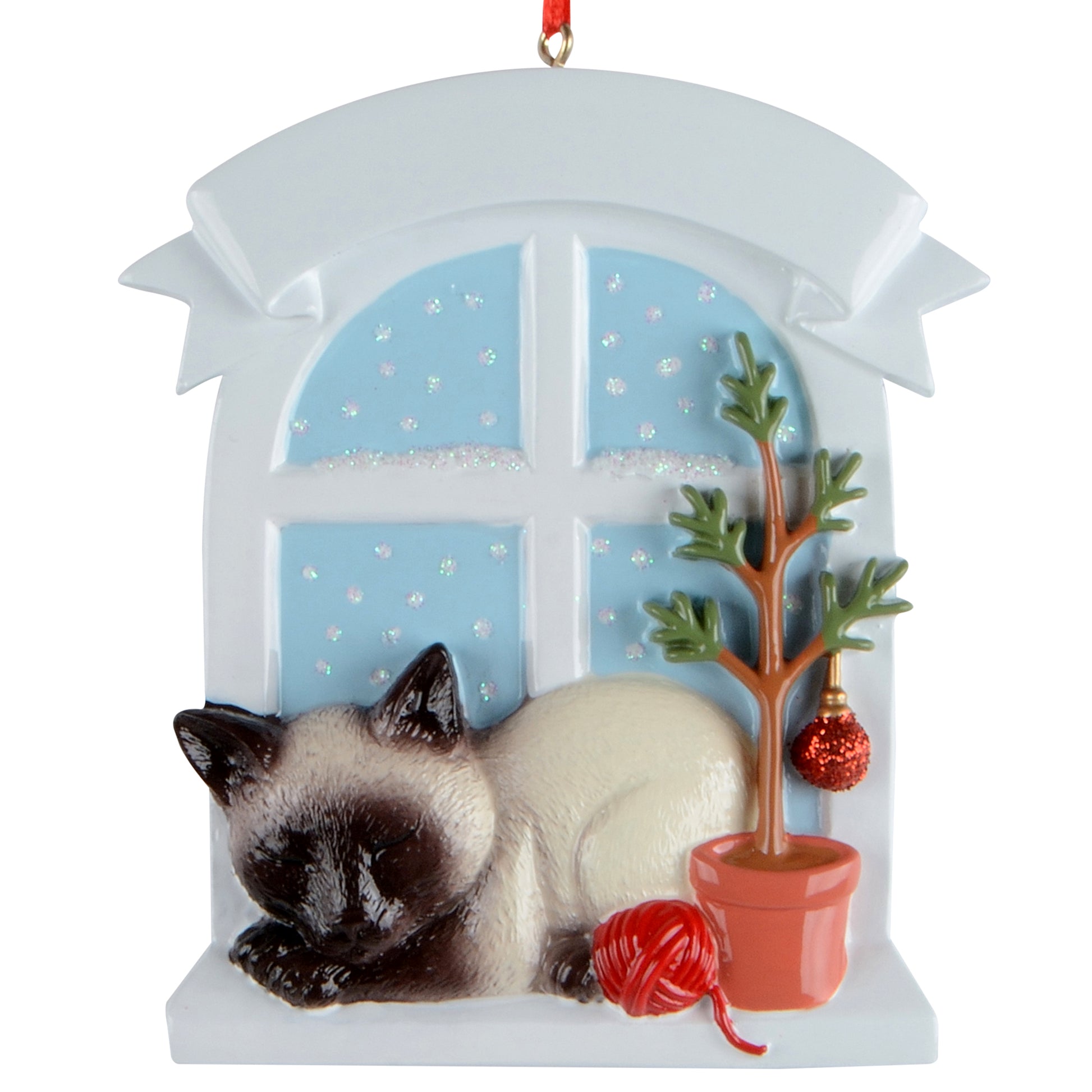 Siamese cat sleeping by window with potted tree and red yarn ball holiday ornament
