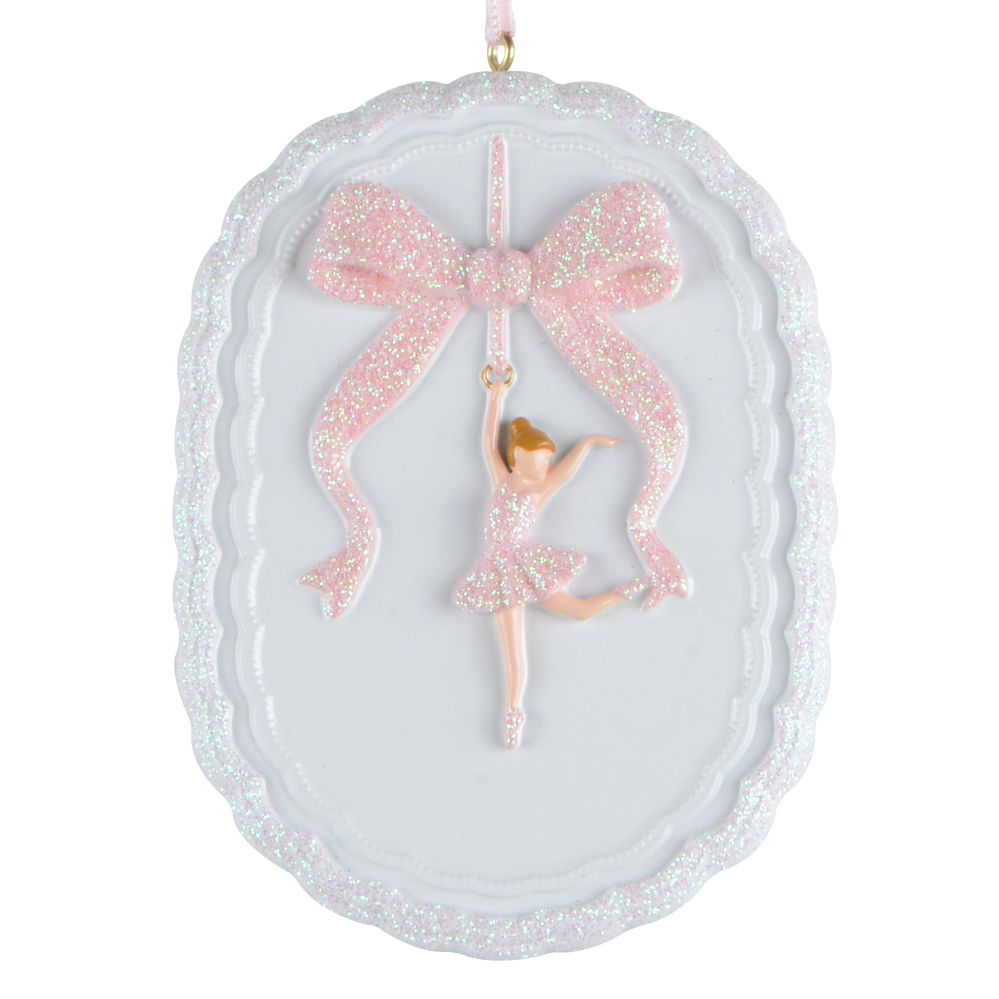 Oval white holiday ornament with scalloped edges featuring a handpainted ballerina in a pink glitter dress hanging from a pink glitter bow