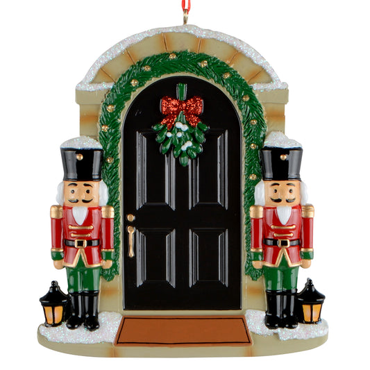 Nutcracker front door holiday ornament featuring two nutcracker figures flanking a black door with green garland and red bow wreath