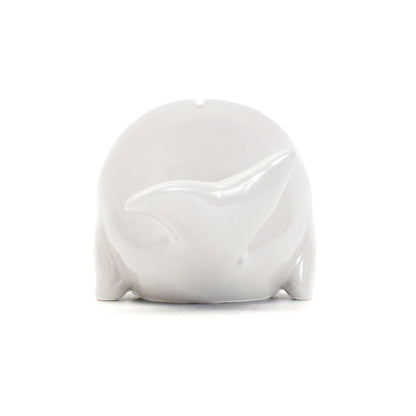 Rear view of white whale piggy bank showing the tail fin and slot on top