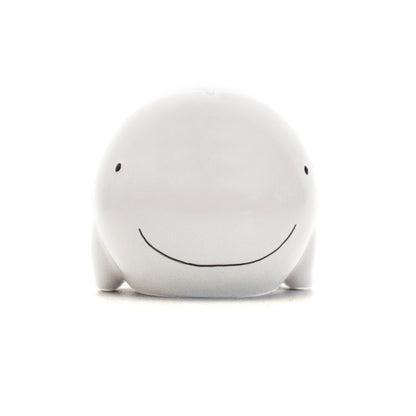 Frontal view of white whale piggy bank smiling with simple black eyes