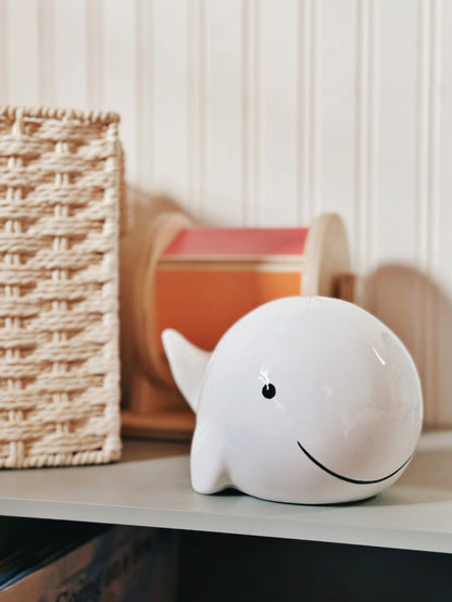 Detailed close-up of whale piggy bank's smiling face and smooth curves