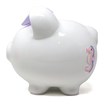 Back view of white ceramic piggy bank showing glittery seahorse decoration