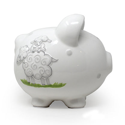 Right profile of white ceramic piggy bank decorated with gray lambs on grass