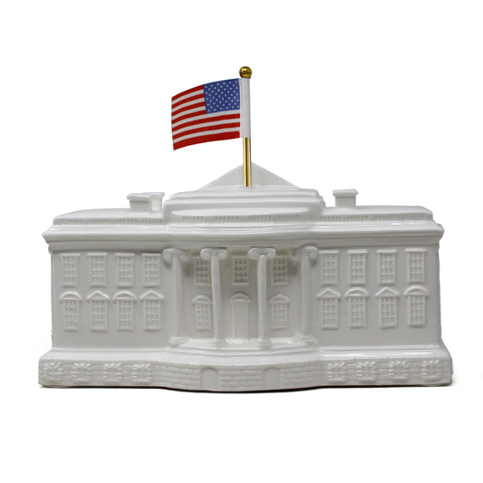 Front view of White House shaped porcelain piggy bank with American flag on gold-tone pole