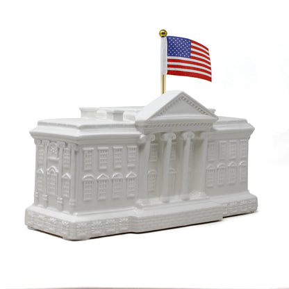 Angled right side view of White House shaped piggy bank with visible architectural details