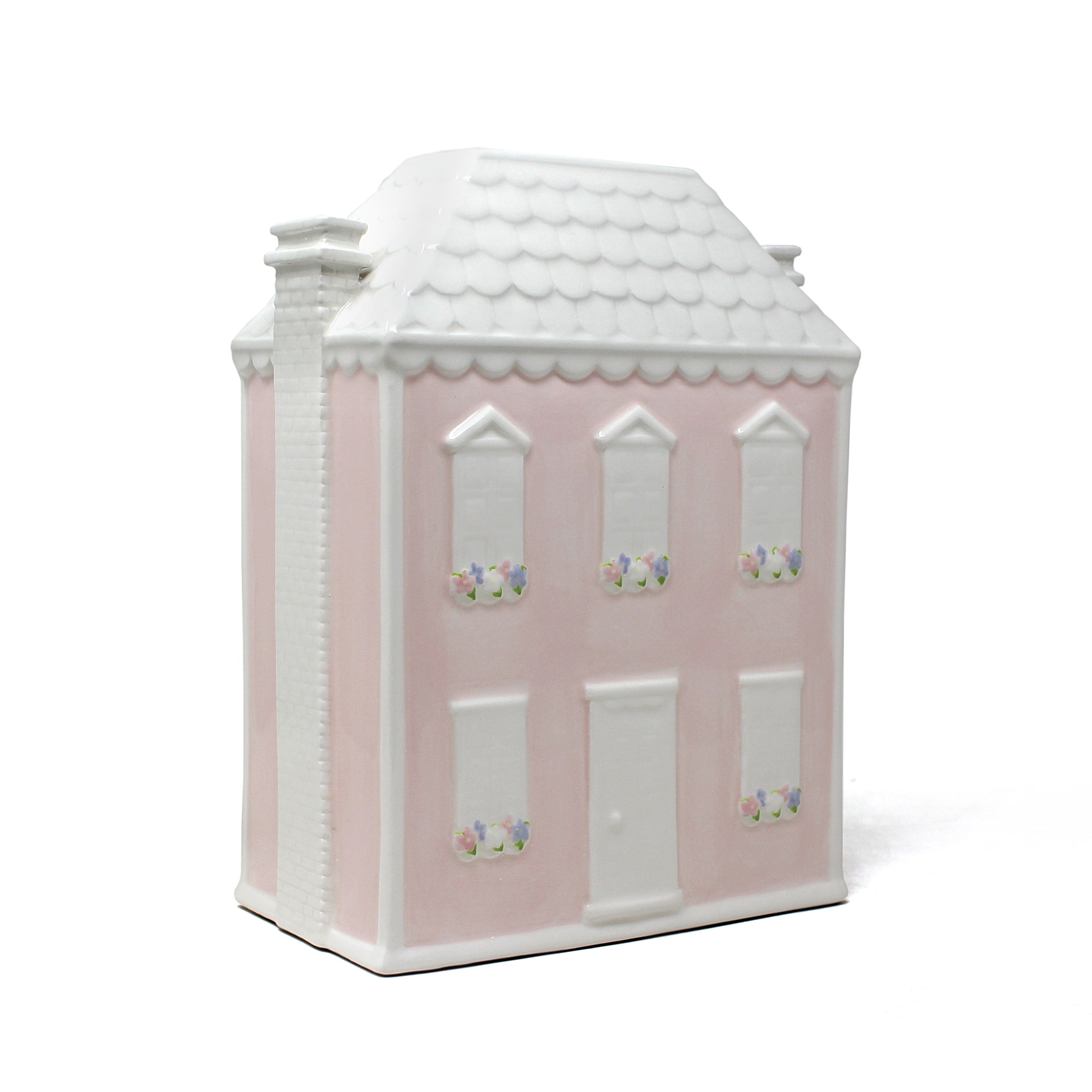 Three-quarter view of Dolly’s House pink ceramic piggy bank with white roof and floral window accents