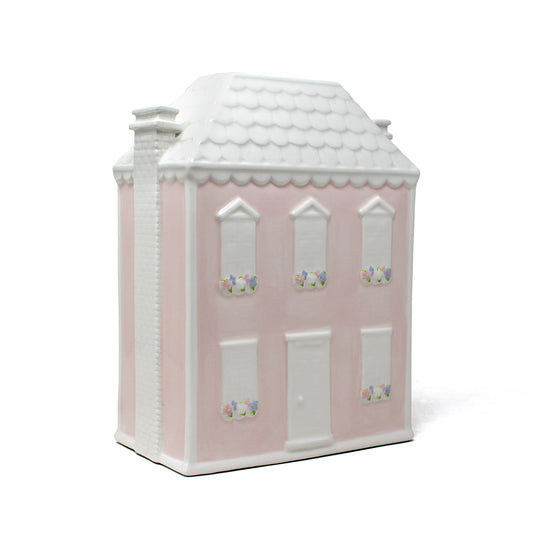 Three-quarter view of Dolly’s House pink ceramic piggy bank with white roof and floral window accents