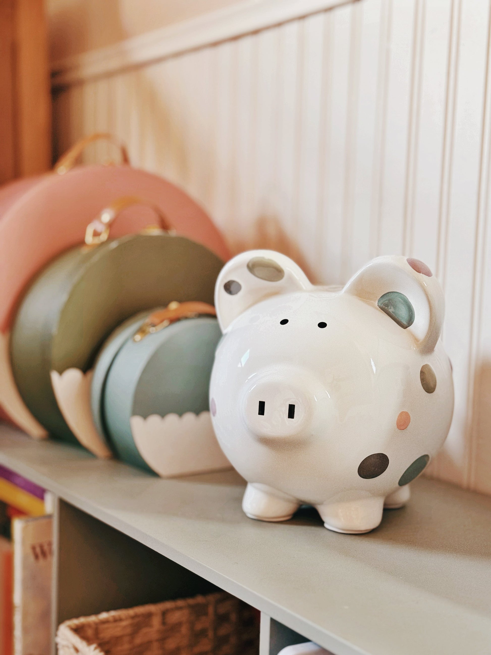 Piggy bank on a wooden surface next to books and toys