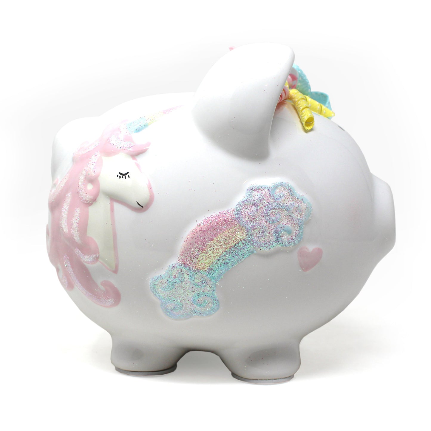 Close-up of unicorn face and glitter decorated rainbow on ceramic piggy bank