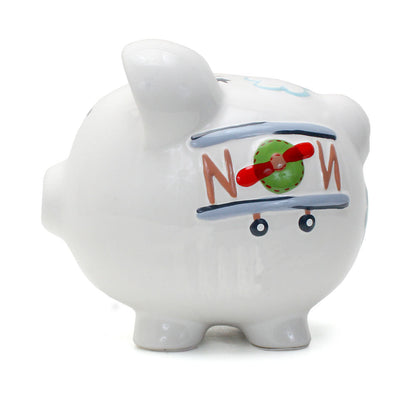 Back side view of white piggy bank showing airplane tail and wheels design