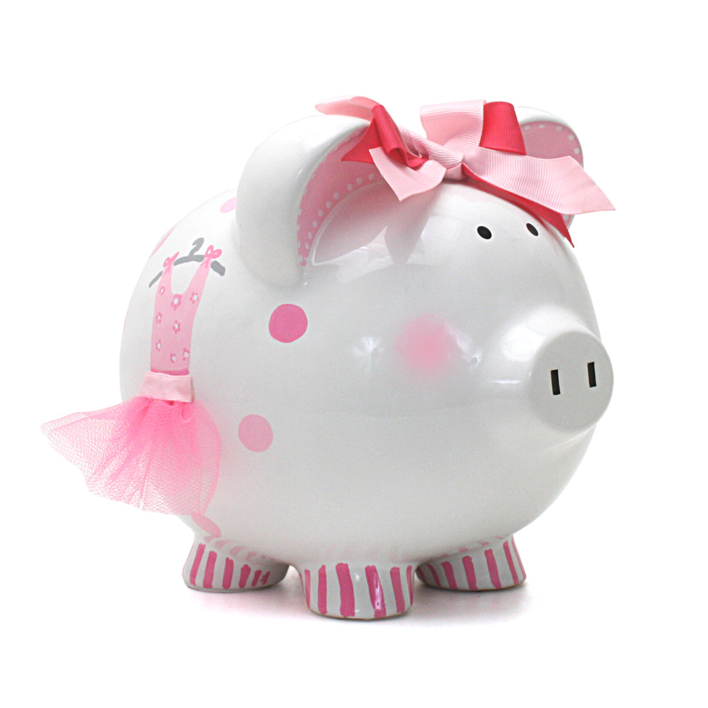 White ceramic piggy bank decorated with pink ballet motifs, a pink tulle tutu on the side, and a double pink ribbon bow on the ear front side view