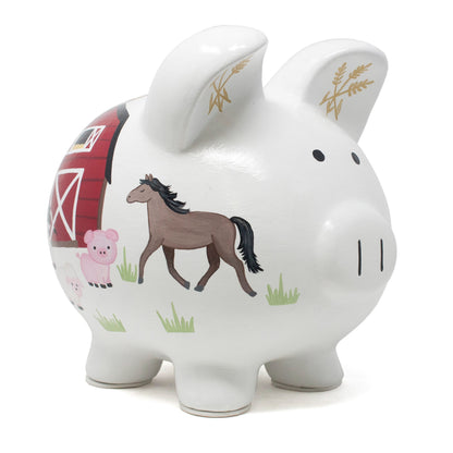 Front side view of white ceramic farmyard piggy bank with handpainted horse, piglet, and barn illustrations