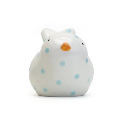 Front view of white bird-shaped piggy bank with blue polka dots and tiny orange beak