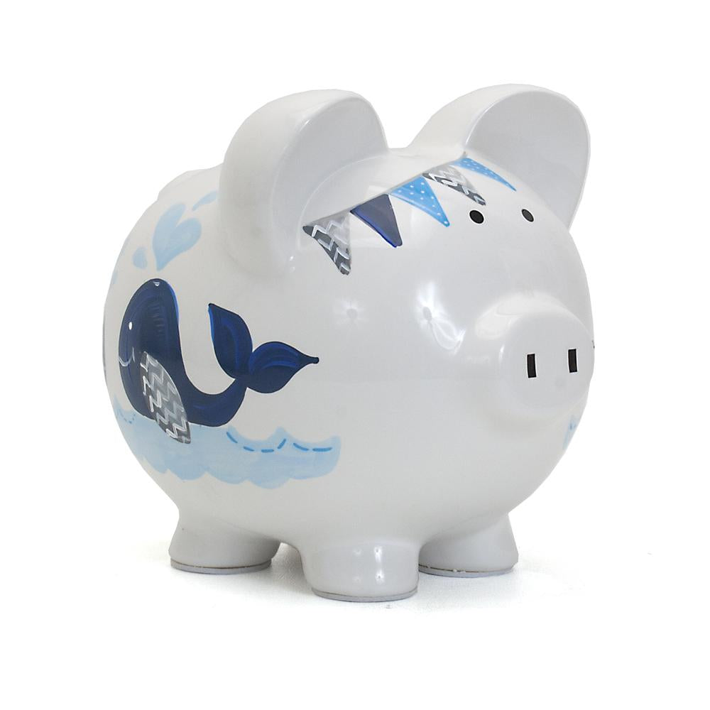 Front side view of white ceramic piggy bank with blue whale handpainted design
