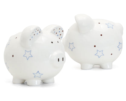 Two white ceramic piggy banks with blue star and brown dot design side by side