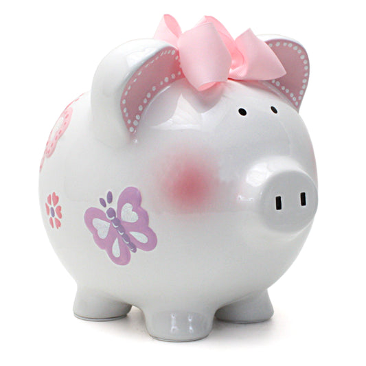 Front diagonal view of white ceramic piggy bank with handpainted butterflies and pink bow