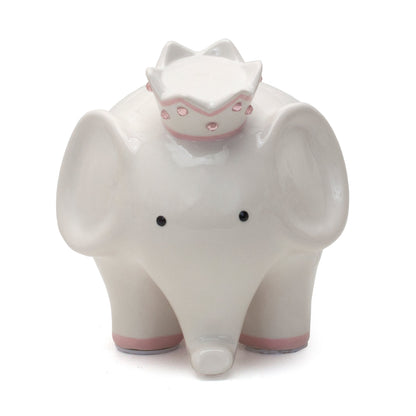 Front view of white ceramic elephant piggy bank with black eyes and pink jeweled crown coin slot