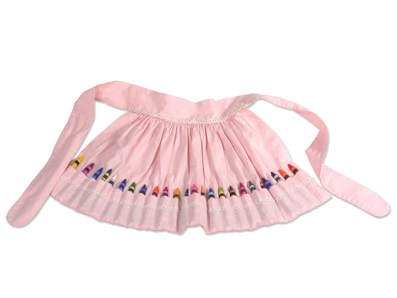 Unpacked pink cotton apron with crayon-sized pockets holding crayons all around and white lace detailing