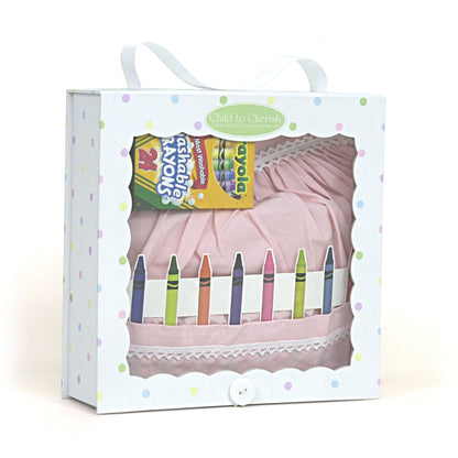Packaged pink cotton crayon apron with white lace trim and 24 washable Crayola crayons in a confetti print box with handle
