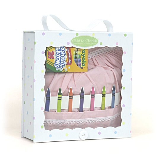 Packaged pink cotton crayon apron with white lace trim and 24 washable Crayola crayons in a confetti print box with handle