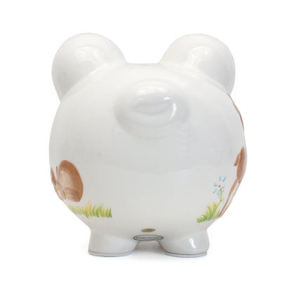 Back view of white ceramic piggy bank showing floral design on ear and sturdy legs