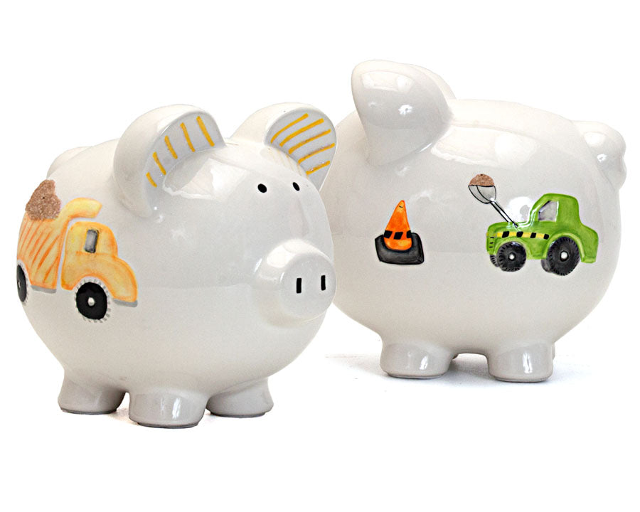 Two handpainted piggy banks side by side displaying dump truck and digger designs on glossy ceramic