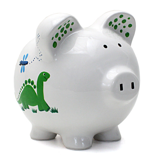 Front side view of white ceramic piggy bank with green dinosaur and dragonfly illustrations