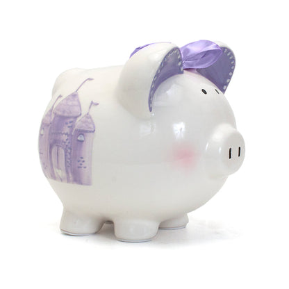 Close side views of white ceramic piggy bank with purple castle and crown motifs and purple bow