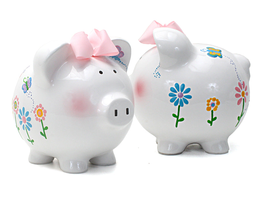 Two ceramic piggy banks side by side, one Flutterfly and one purple with white polka dots