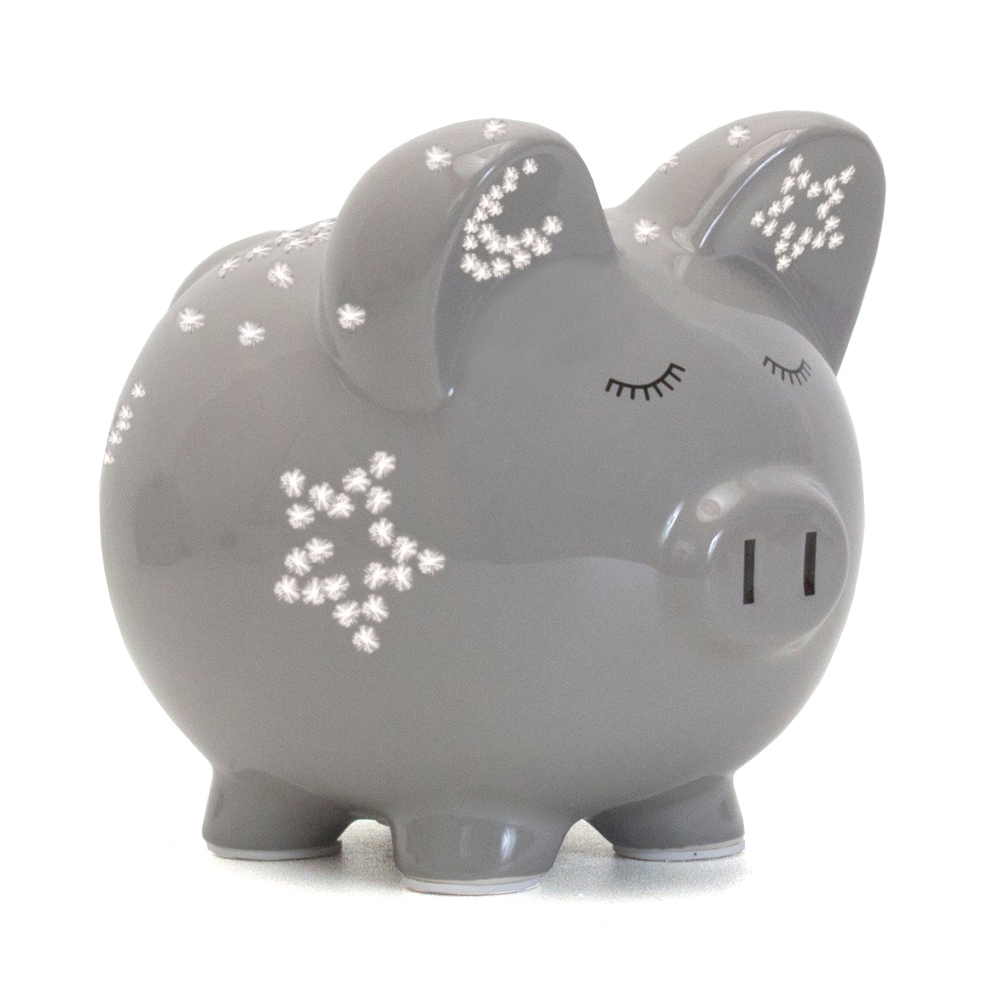 Lit gray ceramic pig night light showing glowing star and crescent moon patterns