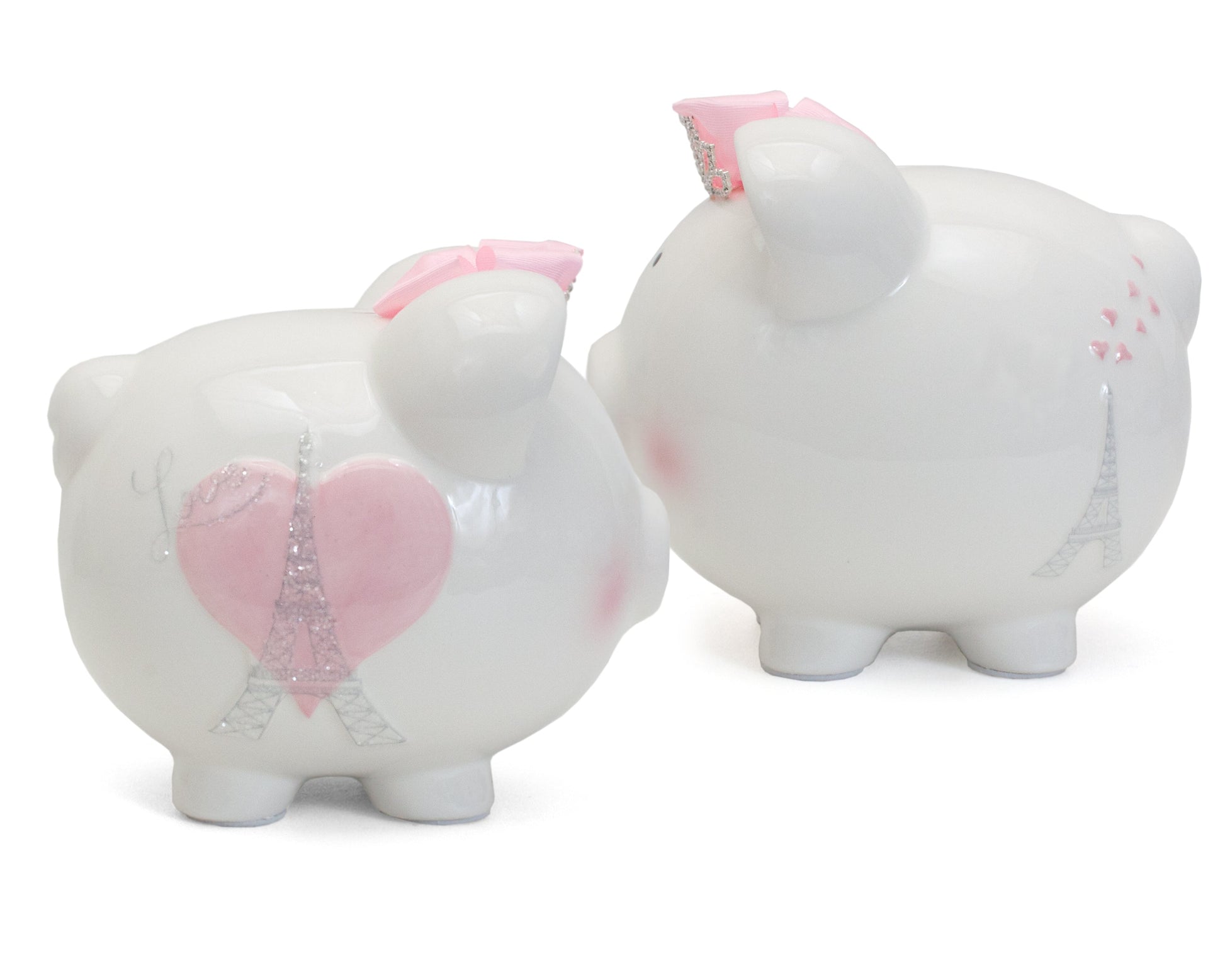 Two white ceramic piggy banks side by side showing front with pink heart and Eiffel Tower and back with Eiffel Tower and hearts designs