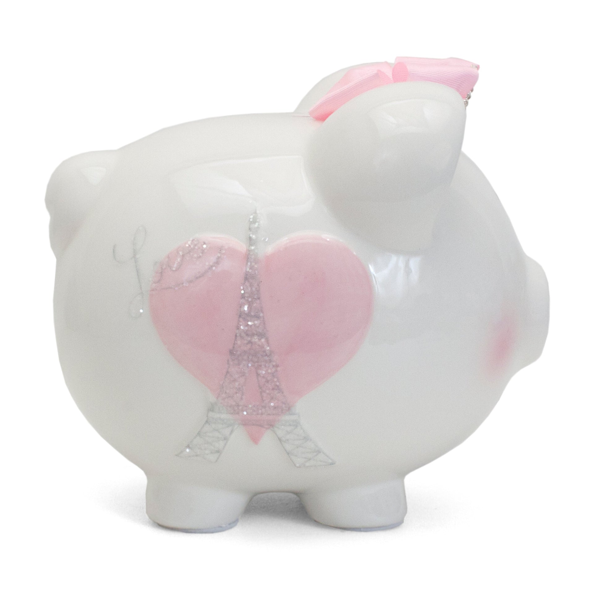 Side view of white ceramic piggy bank with pink heart and glittery Eiffel Tower design, adorned with a pink bow on its ear